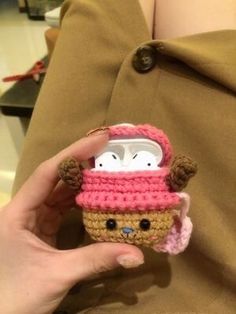 someone is holding up a small crocheted toy