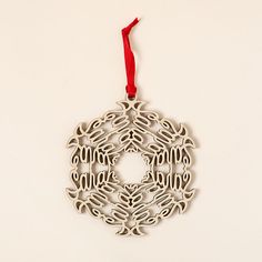 a white ornament hanging from a red ribbon