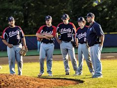 a group of baseball players standing on top of a field