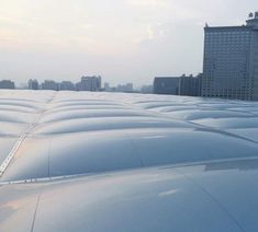 an airplane wing with buildings in the background