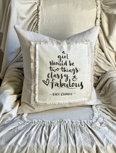 a white pillow sitting on top of a bed next to a wall with words written on it