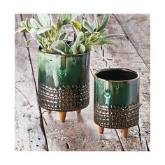 two green planters sitting on top of a wooden table