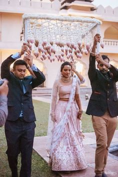 the bride and groom are walking down the aisle with their hands up in the air