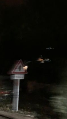 a blurry photo of a street sign at night