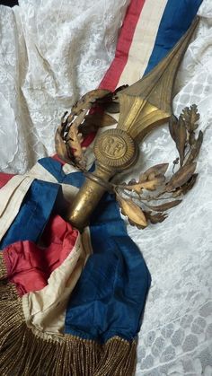 an antique brass clock with red, white and blue ribbons around it