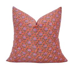 an orange and purple pillow with flowers on it