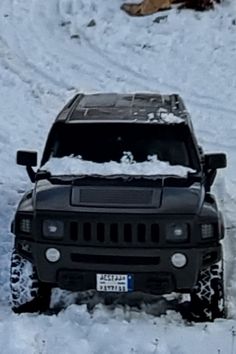 a black jeep driving through the snow