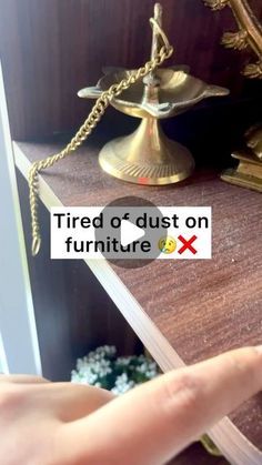 a hand pointing at a sign that says tired or dust on furniture x next to a mirror