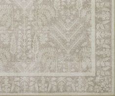 an area rug with white and grey designs on it, including leaves and flowers in the center