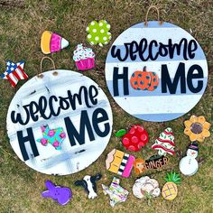 two welcome home signs sitting on top of the grass next to other decorations and magnets