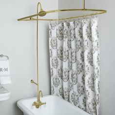 a bathroom with a bathtub, shower curtain and towel rack in gold color on the wall