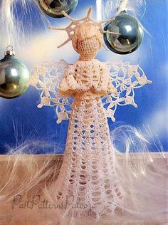 a crocheted angel with ornaments hanging from it's back