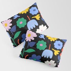 two black pillows with colorful flowers on them