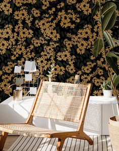 a wooden chair sitting on top of a hard wood floor next to a wall covered in yellow flowers