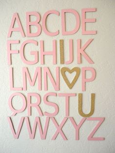 the letters are made out of pink and gold paper