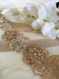 This champagne gold, beaded, and sequined lace bridal sash is a delectable statement for the modern bride. ♥ Beaded portion of front of sash is 18'' long and 1.5'' in width. ♥ 7/8'' Satin Ribbon is 8'. Please feel free to contact me if you would like a longer or shorter satin ribbon.  Hand sewn by me in my New Orleans studio. Gold Embellished Wedding Sash, Gold Beaded Bridal Belt For Party, Gold Embellished Sashes For Wedding, Gold Embroidered Sash For Party, Gold Embroidered Belt Sash For Parties, Gold Embellished Bridal Accessories For Party, Elegant Gold Bridal Belt For Bridesmaids, Embellished Party Sash, Embellished Fitted Sash For Party