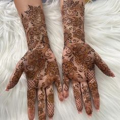 two hands with henna designs on them