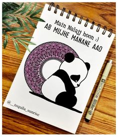 a spiral notebook with an image of a panda on it and a pen next to it