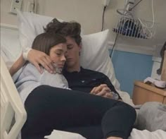 a man and woman cuddling in a hospital bed