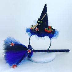 a witches hat with blue tulle and red stars on it, sitting next to a headband