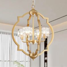 a chandelier hanging from the ceiling in a living room with white walls and curtains