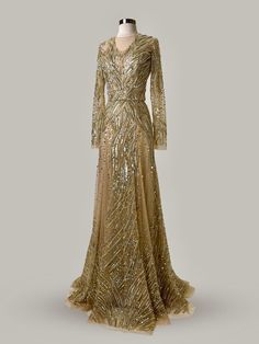 Immerse yourself in the splendor of this Anna Augusta Evening Maxi Dress, a masterpiece in a shimmering gold color. Brand new with tags, this size 8 gown features a breathtaking array of hand-sewn sequins and beads that cascade down its length, creating a dazzling display of light and texture. The dress boasts a flattering, intricately detailed design with long sleeves and a subtle train, ensuring every entrance is as grand as the occasions it graces. Perfect for high-profile events, this gown embodies luxury and elegance. Brand New with Tags: Ensures top quality and untouched elegance. Radiant Gold Sequins and Beads: Offers a stunning, eye-catching sparkle. Elegant Long Sleeves: Adds a touch of sophistication and style. Flawlessly Detailed: Exquisite craftsmanship visible in every aspect. Luxury Shimmer Maxi Dress For Gala, Silver Dresses, Evening Maxi Dress, Gold Evening Dresses, Detailed Design, Maxi Dress Evening, Gold Sequins, Gold Branding, Silver Dress