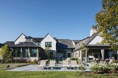 a large white house sitting on top of a lush green field