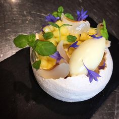 a plate with some food on it sitting on top of a wooden table and black surface