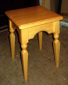 a small wooden table sitting on top of a tile floor