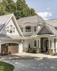 a large white house with two garages on the front and one story above it