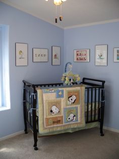 a baby's room with blue walls and pictures on the wall, including a crib