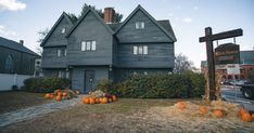 an old house with pumpkins on the front lawn