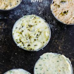 four cups filled with different types of food on top of a black surface, labeled butter