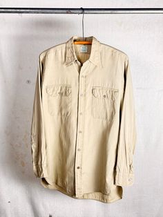 An authentic vintage long sleeve twill work shirt. Conquerer label. sanforized. "Burton's Poplin" mediumweight fabric. era : 1950s to early 60s material : cotton color : khaki *color may vary slightly in photos than in person condition : great , appropriate signs of age and wear as seen in photos size : tagged adult medium , please compare measurements below actual garment measurements : chest :  22" pit to pit  shoulder : 17.5" sleeve : 24.5" length : 31" - - - - - - - - - - - - - - - - - - - - - - - - - - - - - - - - - - - - - - - -  INTERNATIONAL SHIPPING AVAILABLE UPON REQUEST Craft Union does NOT accept returns or exchanges, all items are FINAL SALE Please consider the following prior to placing an order : Because measurements are provided, Craft Union does NOT grant refund/exchange r Classic Long Sleeve Pre-washed Shirt, Vintage Unstructured Collared Tops, Unstructured Collared Vintage Tops, Vintage Pre-washed Fall Shirt, Vintage Unstructured Shirt For Workwear, Unstructured Vintage Shirt For Work, Vintage Unstructured Button-up Shirt, Vintage Unstructured Shirt With Pockets, Vintage Workwear Shirt With Pockets