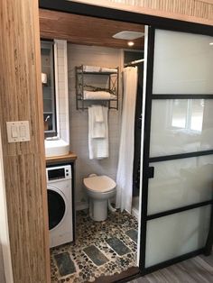 a bathroom with a toilet, washer and dryer in it