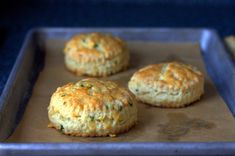 three biscuits sitting on top of a cookie sheet