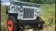 an old jeep is parked in the grass