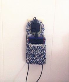 a cell phone hanging on a wall with a cord attached to the back of it