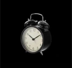 an alarm clock on a black background with no time left to tell it's past