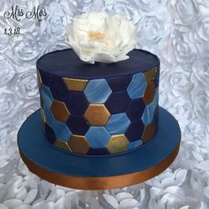 a blue and gold cake with a flower on top