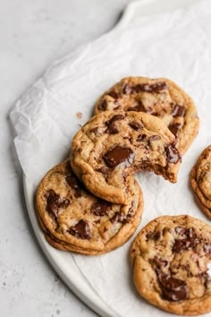 several chocolate chip cookies on a white plate