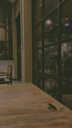 a wooden table in front of a glass door with an animal on it's side