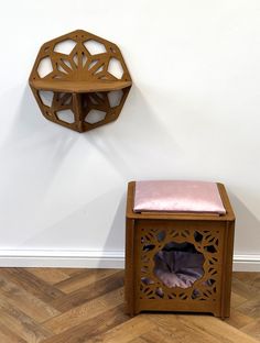 a small wooden bench sitting next to a wall mounted shelf with a pink cushion on it