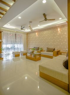 a living room filled with furniture and a ceiling fan in the middle of the room