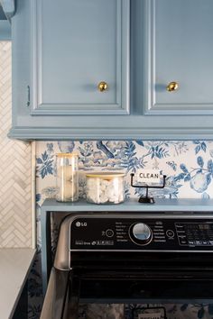 a stove top oven sitting inside of a kitchen next to blue cupboards and counter tops