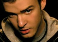 a close up of a person wearing a jacket and looking at the camera with an intense look on his face