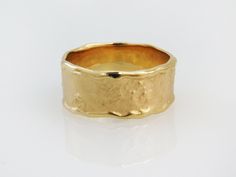 a gold wedding ring on a white background