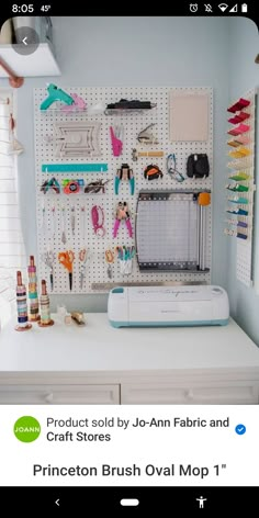 a white desk topped with lots of crafting supplies next to a wall mounted pegboard