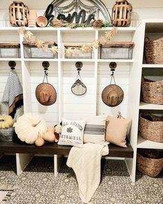 a room filled with lots of white shelves and baskets