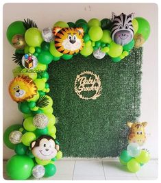 an animal themed balloon arch for a baby's birthday party with jungle animals and zebras